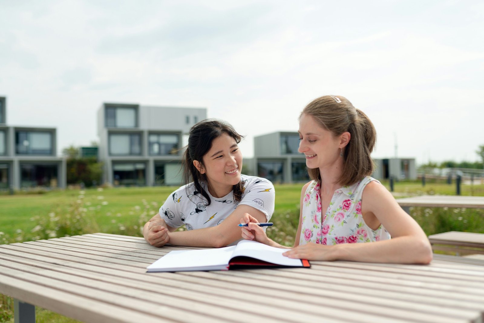 2 girls sitting on wooden dock during daytime